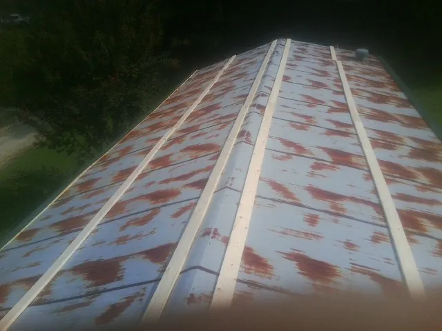 Rusted metal roof panels with new wood purlins before replacement — Storm Damage Roof Repair in Sciota by Roofing Brothers